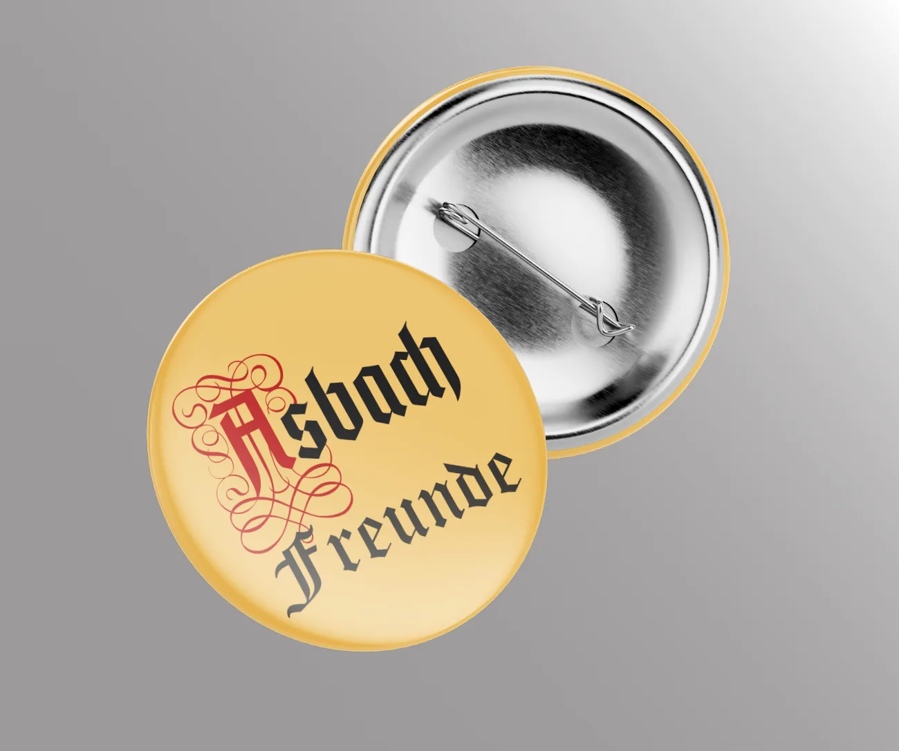 Goldgelber Button mit dem Schriftzug Asbach Freunde in Frakturschrift