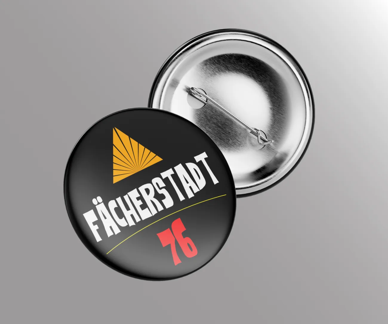 Schwarzer Button mit gelbem Fächer und dem Schriftzug Fächerstadt 76