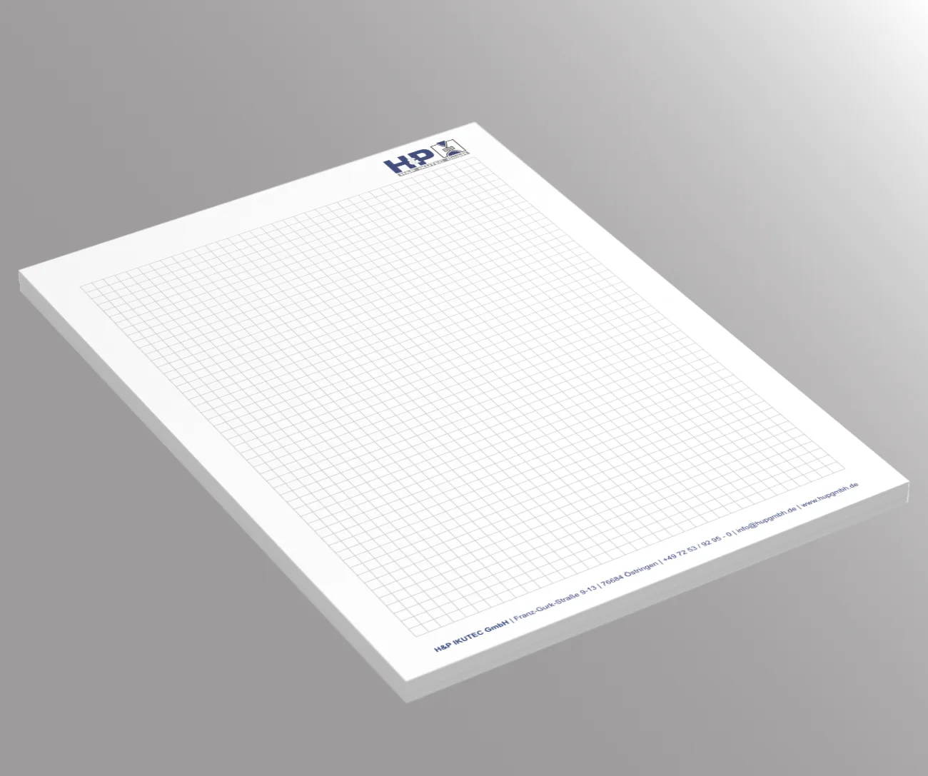 Karierter Schreibblock mit dem blauen Logo HP oben rechts