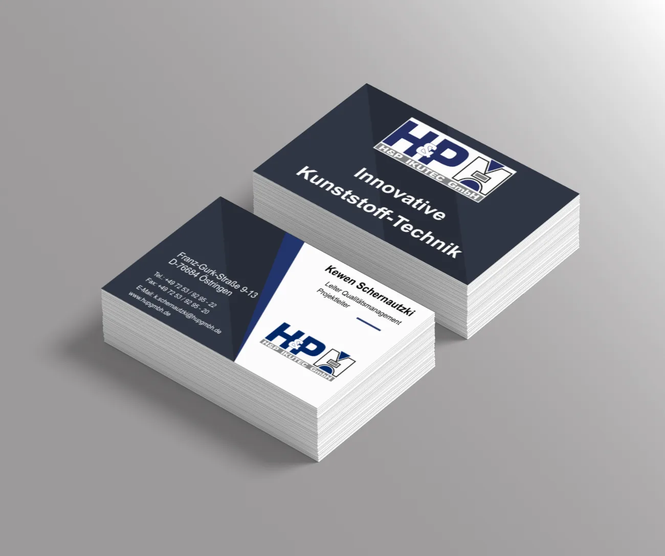 Dunkelblaue Visitenkarten mit dem Logo HP und dem Firmenslogan in Weiß